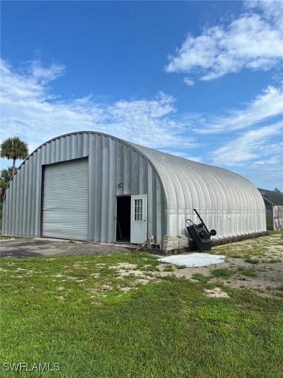 view of outdoor structure featuring a lawn and a garage