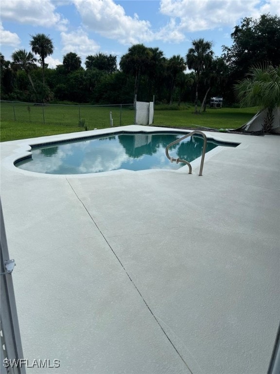 view of swimming pool with a patio and a yard