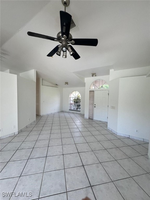 unfurnished room featuring ceiling fan, lofted ceiling, and light tile patterned floors