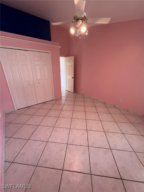 unfurnished bedroom featuring a closet, light tile patterned floors, and ceiling fan