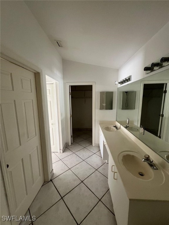 bathroom with vanity, lofted ceiling, and tile patterned floors