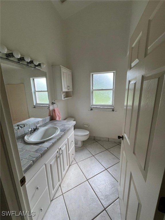 bathroom featuring vanity, toilet, and tile patterned flooring