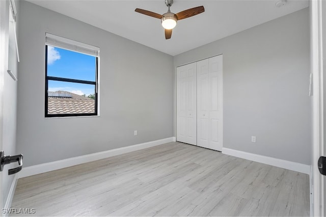 unfurnished bedroom featuring light hardwood / wood-style flooring, a closet, and ceiling fan