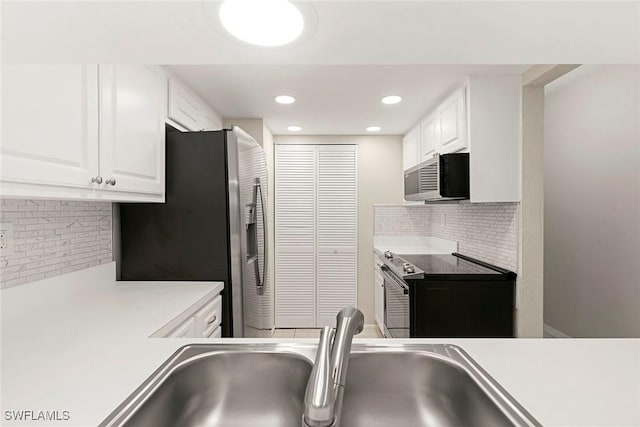 14 Manor Ter Unit 9-106, Marco Island, FL 34145 - kitchen with appliances with stainless steel finishes, decorative backsplash, white cabinetry, light countertops, and recessed lighting