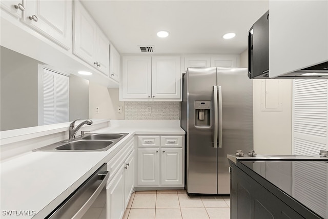 kitchen featuring white cabinets, stainless steel appliances, sink, and light tile patterned floors