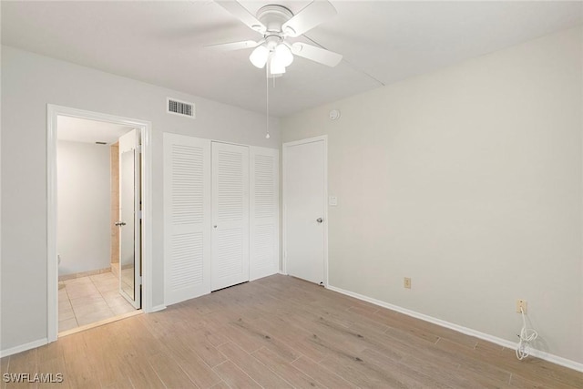 14 Manor Ter Unit 9-106, Marco Island, FL 34145 - unfurnished bedroom featuring light wood-style flooring, a closet, ensuite bath, and a ceiling fan