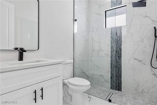 bathroom with vanity, toilet, and tiled shower