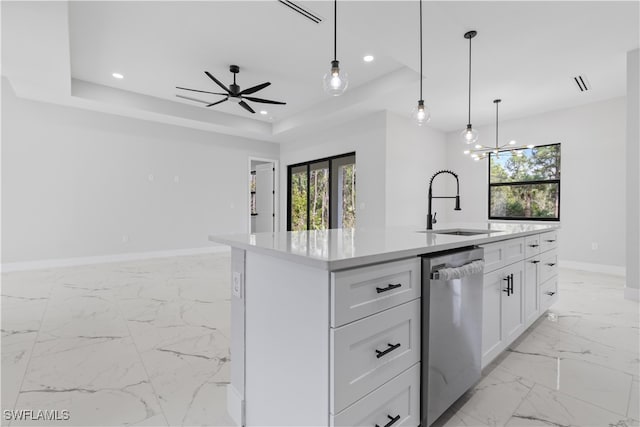 kitchen featuring stainless steel dishwasher, white cabinets, a healthy amount of sunlight, and an island with sink