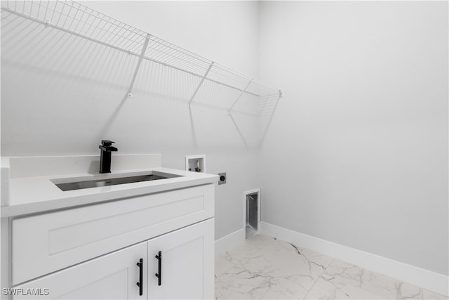 clothes washing area with sink, electric dryer hookup, washer hookup, and cabinets