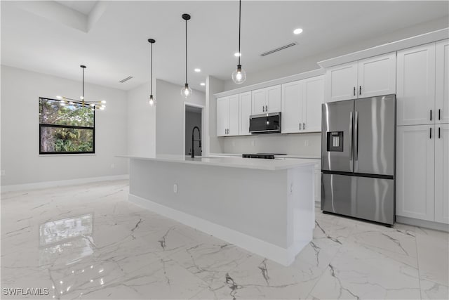 kitchen featuring a center island with sink, appliances with stainless steel finishes, hanging light fixtures, and white cabinetry