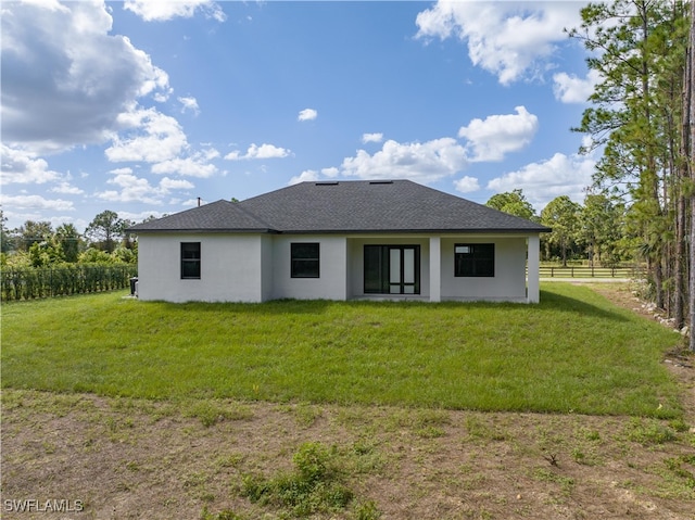 rear view of house featuring a lawn