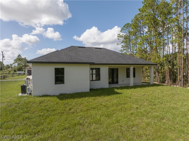 rear view of property with a lawn