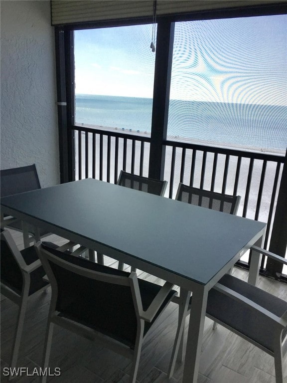 balcony featuring a beach view and a water view