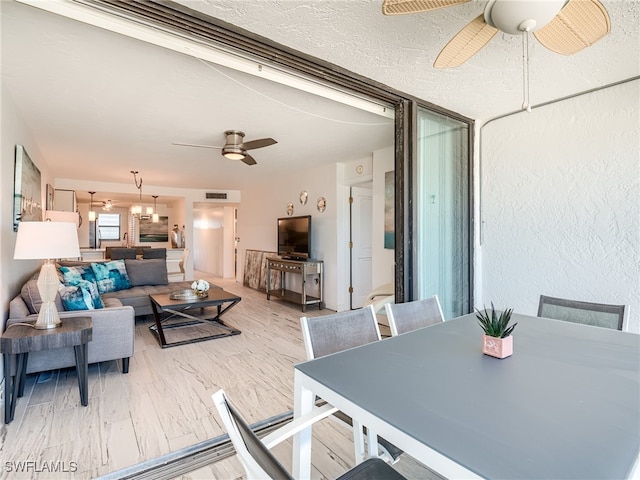 dining room featuring a textured ceiling, light hardwood / wood-style floors, and ceiling fan