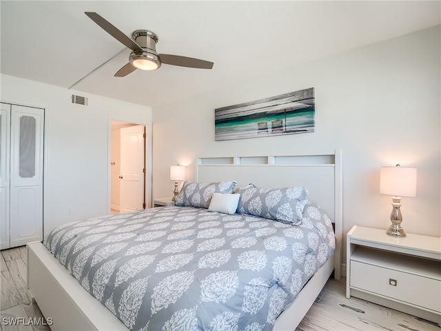 bedroom featuring light hardwood / wood-style floors, ceiling fan, and a closet