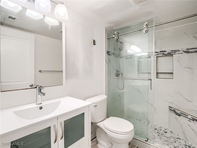 bathroom featuring an enclosed shower, vanity, and toilet