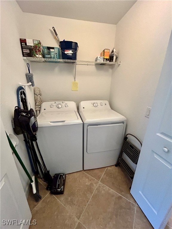 washroom with washer and clothes dryer and tile patterned flooring