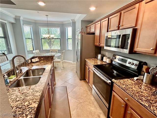 kitchen with light stone countertops, sink, hanging light fixtures, stainless steel appliances, and light tile patterned floors