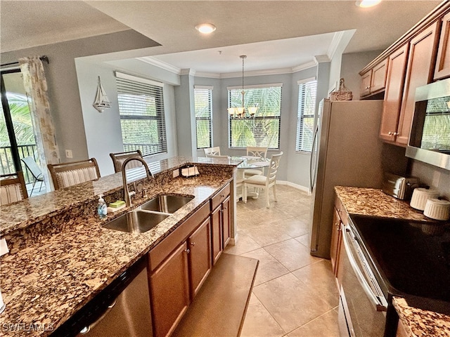 kitchen with appliances with stainless steel finishes, stone countertops, sink, crown molding, and decorative light fixtures