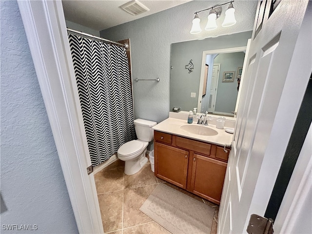 bathroom with vanity, a textured ceiling, toilet, and tile patterned flooring