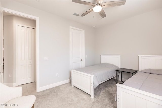 carpeted bedroom featuring a closet and ceiling fan