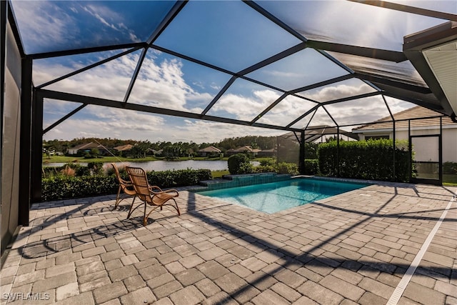 view of pool featuring a patio, a water view, and glass enclosure