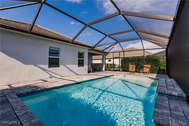 view of swimming pool featuring a patio area and glass enclosure