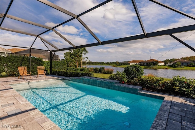 view of pool with a water view, a patio, pool water feature, and glass enclosure