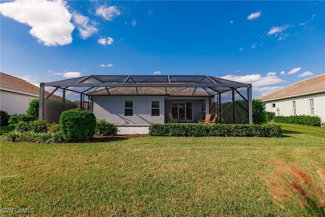 back of property featuring a yard and glass enclosure