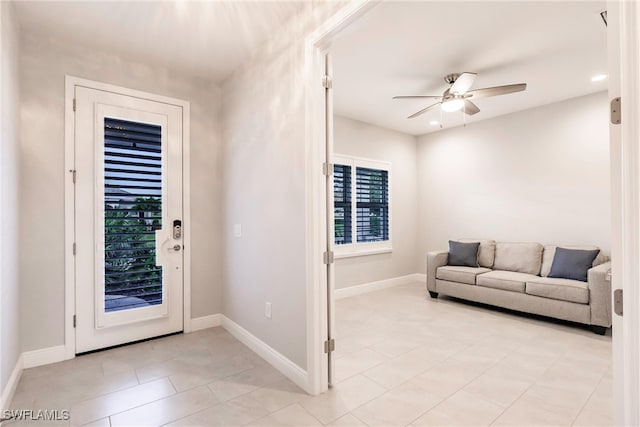 foyer entrance with ceiling fan and light tile patterned floors