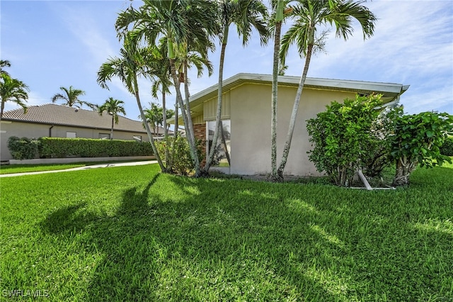 view of side of home with a lawn