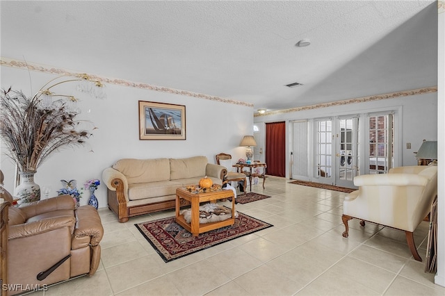 living room with french doors, a textured ceiling, and light tile patterned flooring