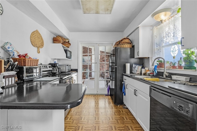 kitchen with white cabinetry, light parquet flooring, black appliances, and a wealth of natural light