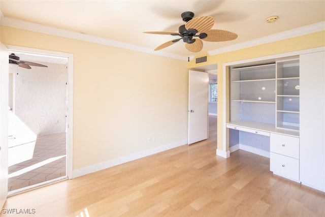 unfurnished bedroom with light hardwood / wood-style flooring, ornamental molding, built in desk, and ceiling fan