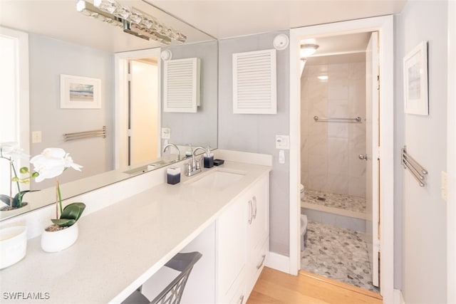 bathroom featuring vanity, hardwood / wood-style floors, and tiled shower