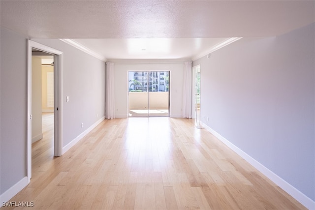 unfurnished room featuring light hardwood / wood-style floors, ornamental molding, and a textured ceiling