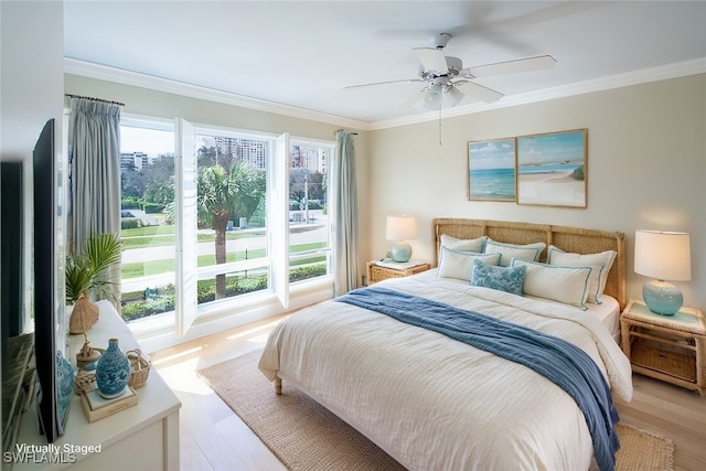 bedroom featuring crown molding, multiple windows, and light wood-type flooring