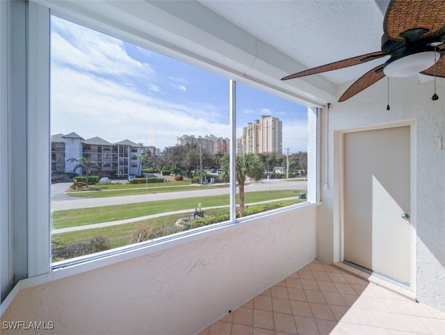 unfurnished sunroom with ceiling fan