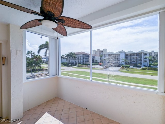 unfurnished sunroom featuring ceiling fan