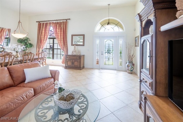 living room with high vaulted ceiling, a healthy amount of sunlight, and light tile patterned flooring