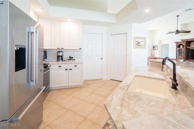 kitchen with stainless steel appliances, ceiling fan, sink, white cabinets, and light tile patterned flooring