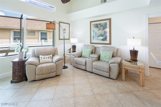 living room with light tile patterned floors and a towering ceiling