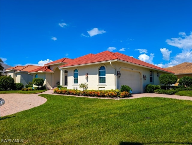 mediterranean / spanish-style house with a garage and a front yard