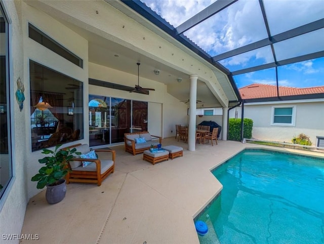 view of pool with glass enclosure, ceiling fan, a patio, and an outdoor hangout area