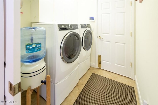 laundry room with light tile patterned flooring and washing machine and clothes dryer