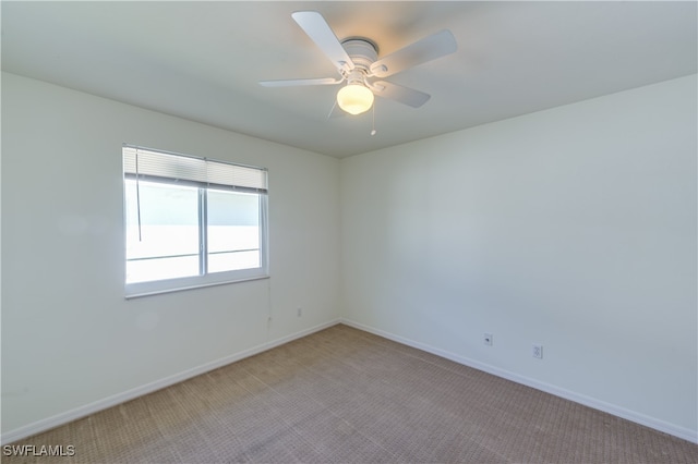 spare room with light colored carpet and ceiling fan