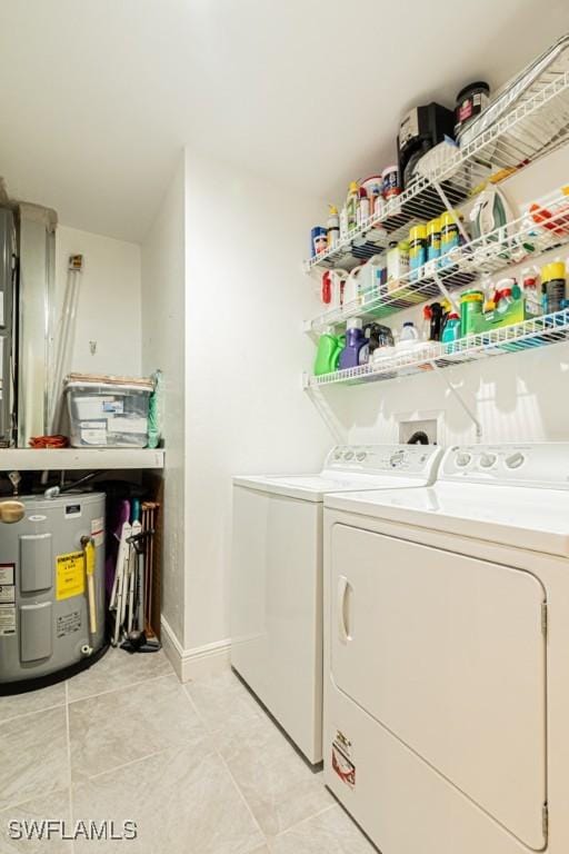 laundry room with water heater, light tile patterned floors, and washing machine and dryer