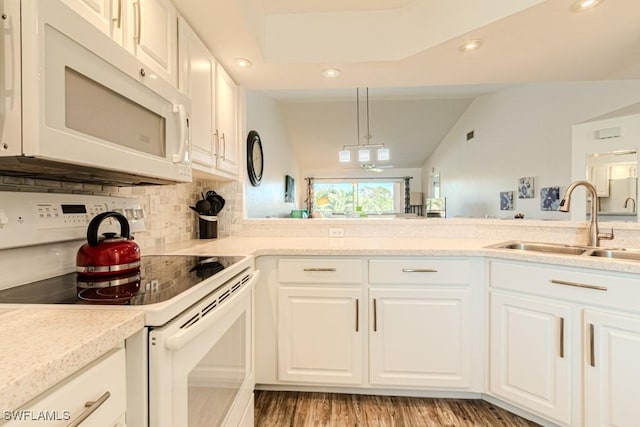 kitchen with white cabinetry, decorative backsplash, white appliances, vaulted ceiling, and sink