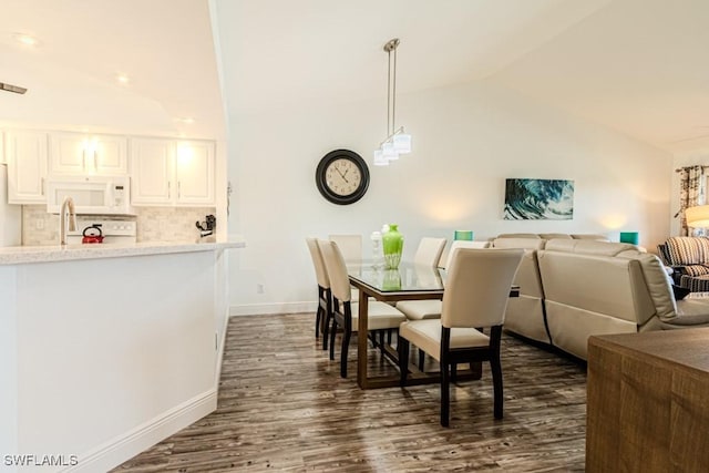 dining room featuring dark hardwood / wood-style flooring and lofted ceiling