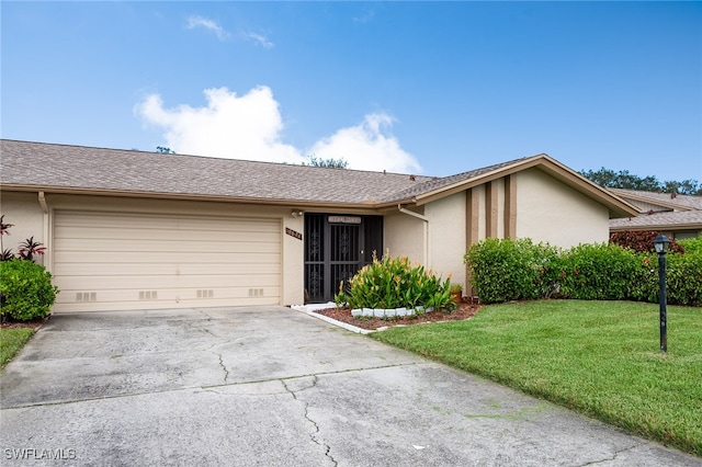 ranch-style house featuring a front lawn and a garage